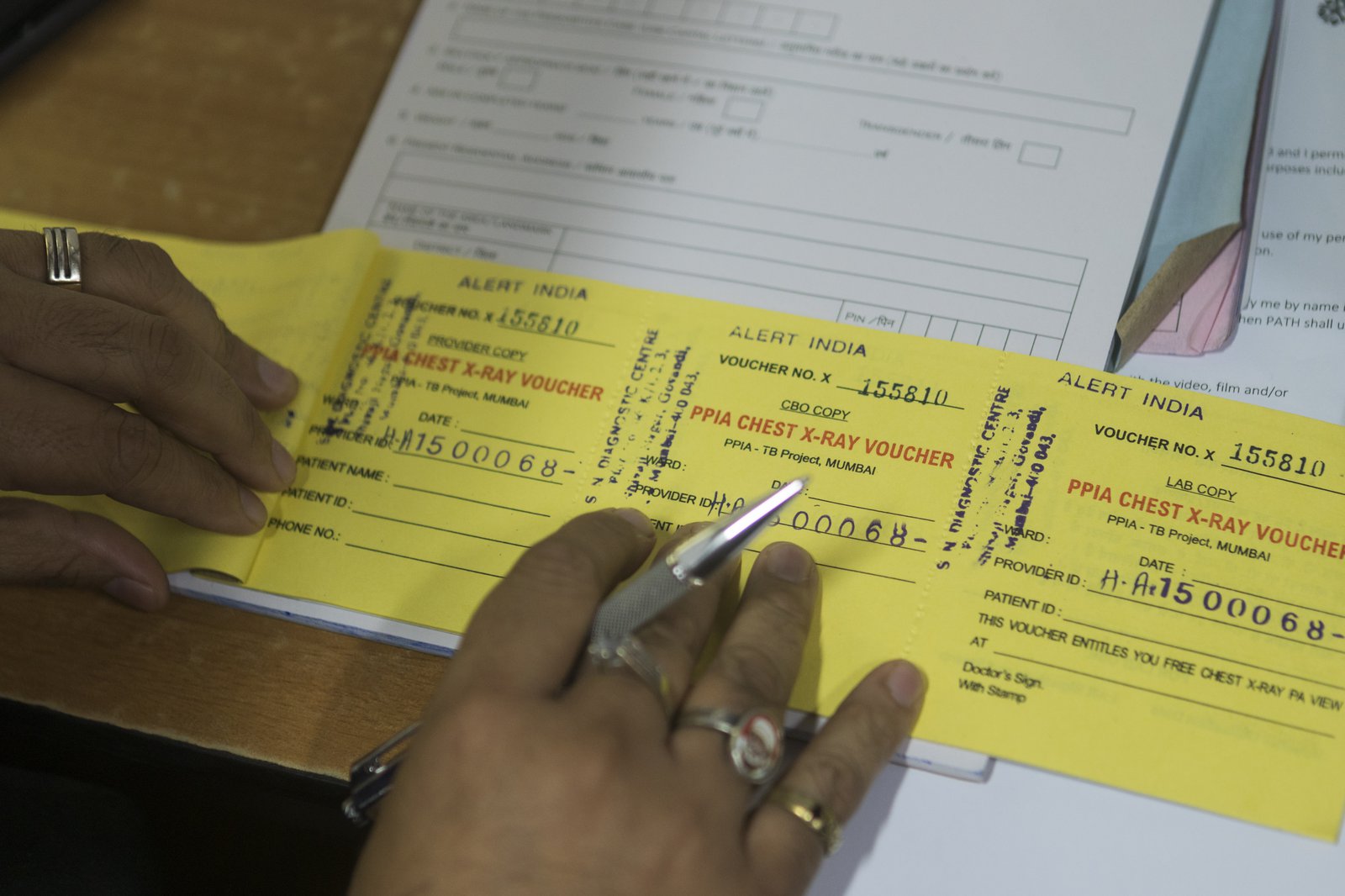 A doctor fills out a PPIA chest X-Ray voucher for a patient who has come for tuberculosis treatment in Mumbai, India. Photo: PATH/Prashant Vishwanathan