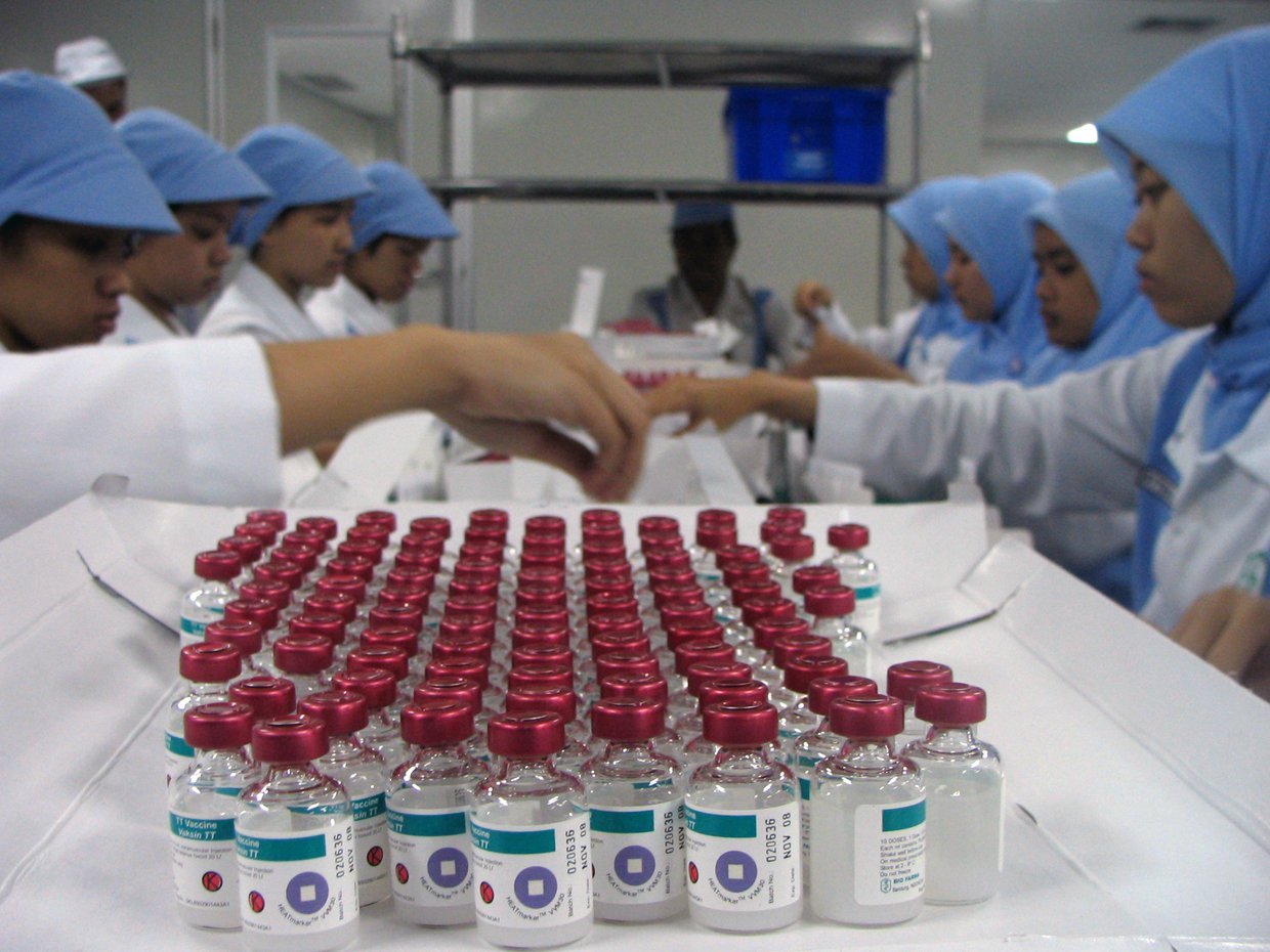 Lab workers in Indonesia examining vaccines that utilize vaccine vial monitors.