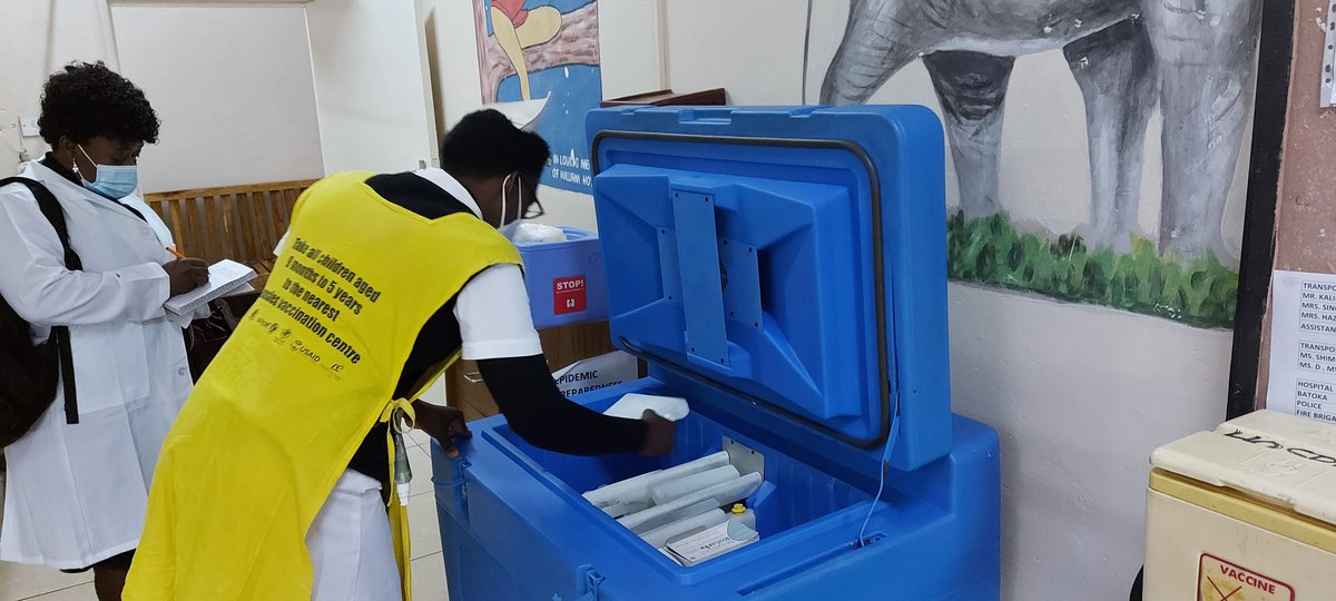 Agnes Mulyata, a nurse at St. Joseph’s Hospice in Livingstone, Zambia, shows Lucy Daka, chief performance improvement officer in Zambia’s Ministry of Health, how she maintains vaccine cold storage.