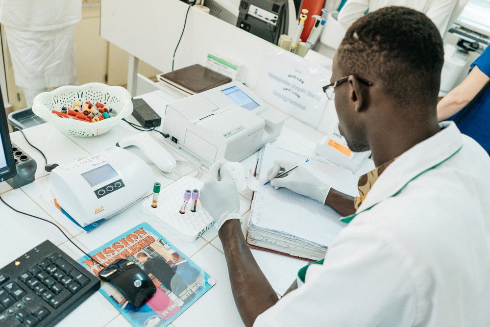 A laboratory worker filling out paperwork in the regional hospital laboratory in Thiès, Senegal. Connected diagnostics have the potential to save health workers valuable time—and accelerate pandemic response times. Photo: PATH/Gabe Bienczycki.
