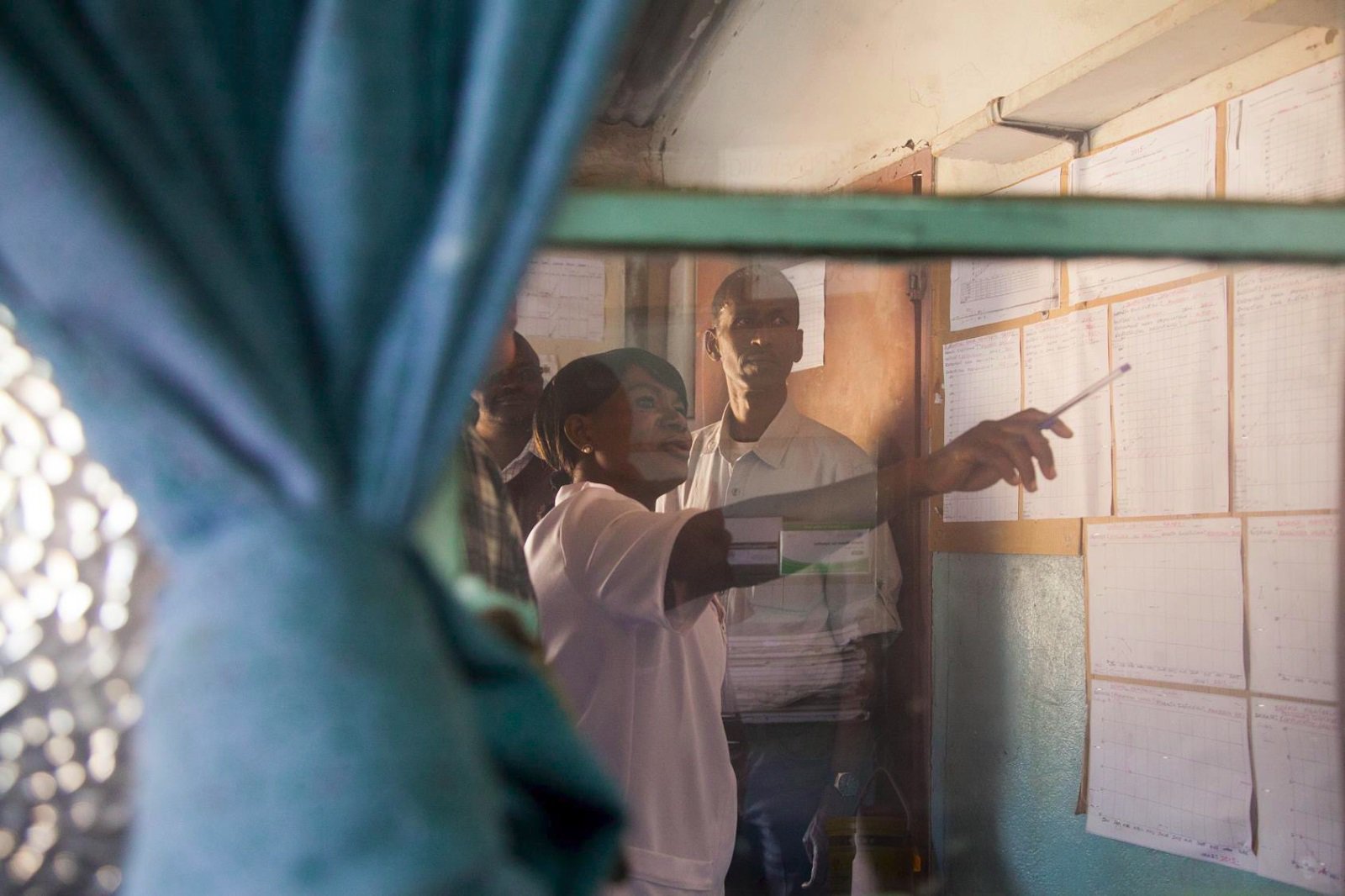 A group of people look at maps on the wall.