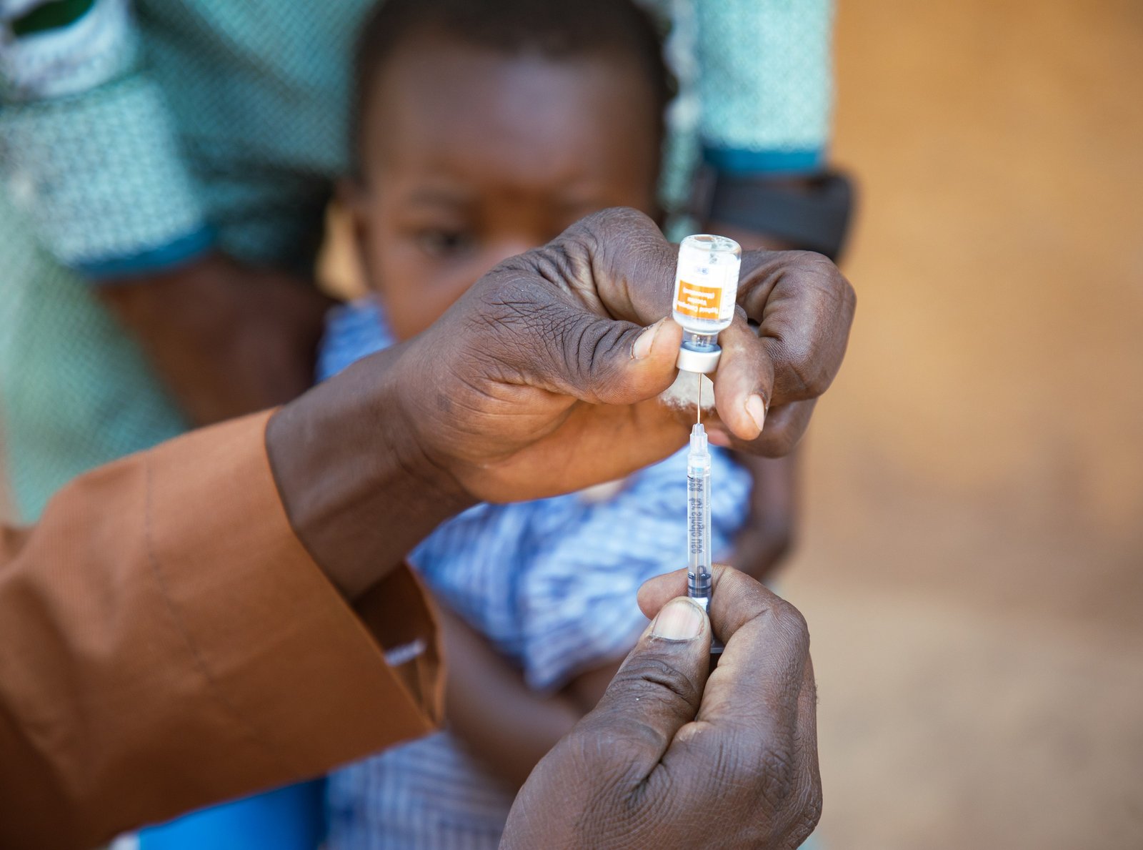 A health care worker prepares a dose of typhoid conjugate vaccine for administration in Burkina Faso. Photo: PATH/Build Africa Communications.