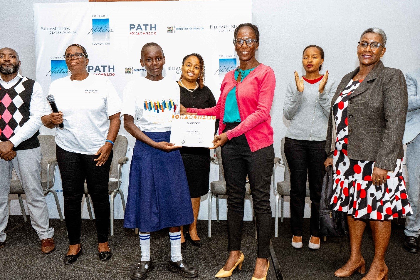 Photo: PATH. Barbra, a primary school student in Kenya, receives a certificate for her poem about HPV awareness.