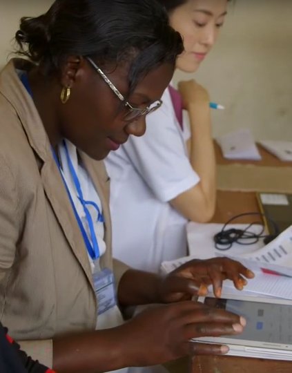 A health care worker uses a tablet to record medical data.