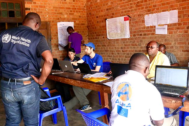 People meet around a large table in a room.