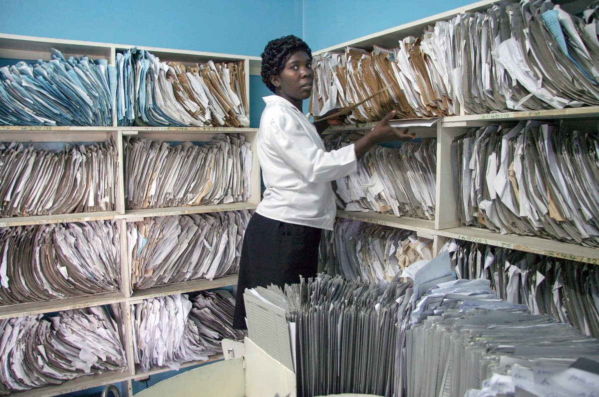 A medical practitioner in Kenya searches for a health record in a data room in a national health facility. Photo: PATH.