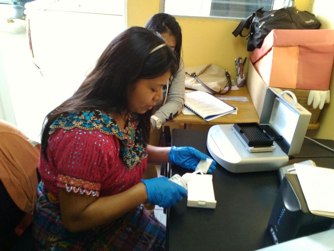 A woman looks at a test result in a lab.