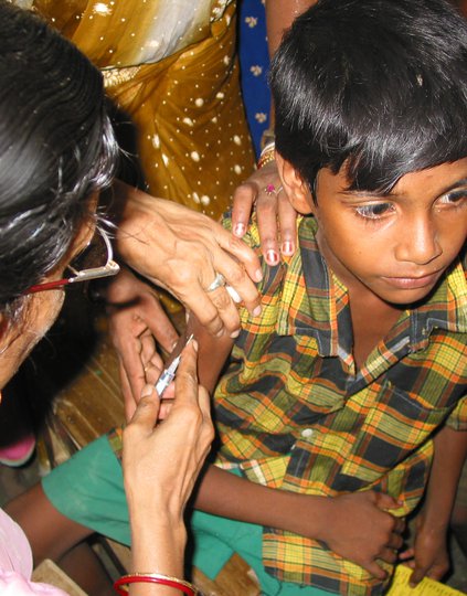 Boy receives vaccination in arm from woman.