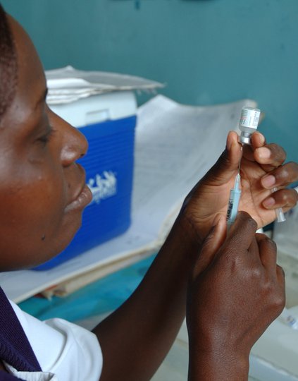A healthcare worker in Kenya prepares a routine immunization. PATH/Wendy Stone