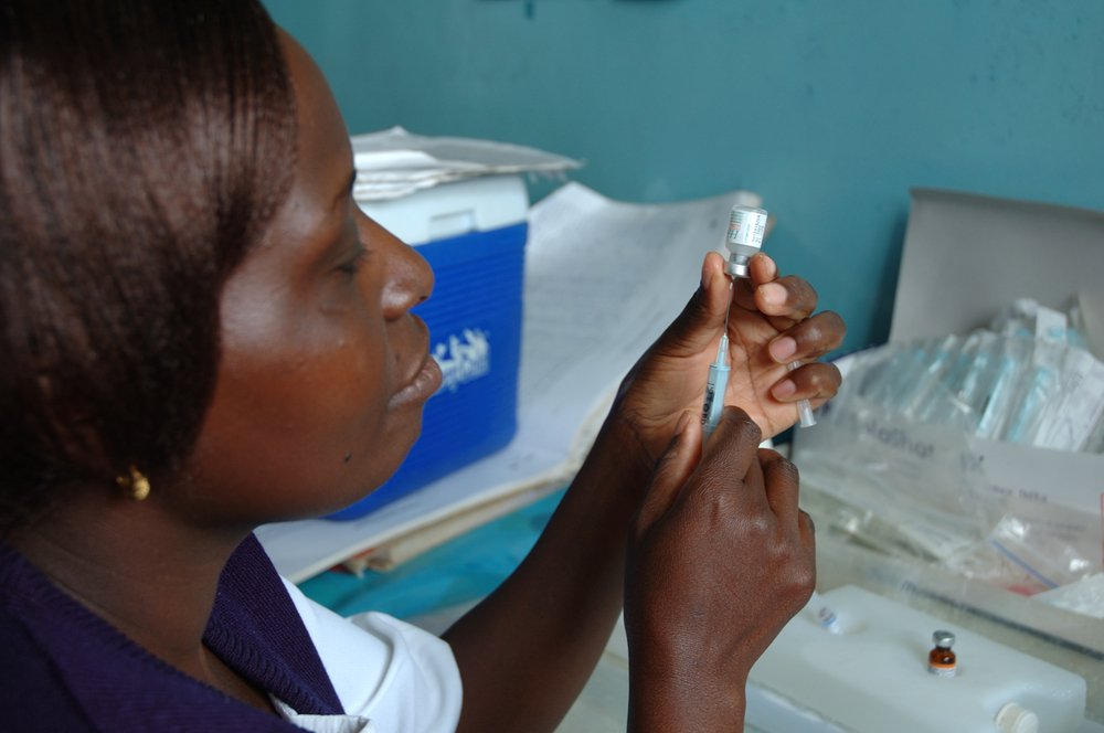 A healthcare worker in Kenya prepares a routine immunization. PATH/Wendy Stone