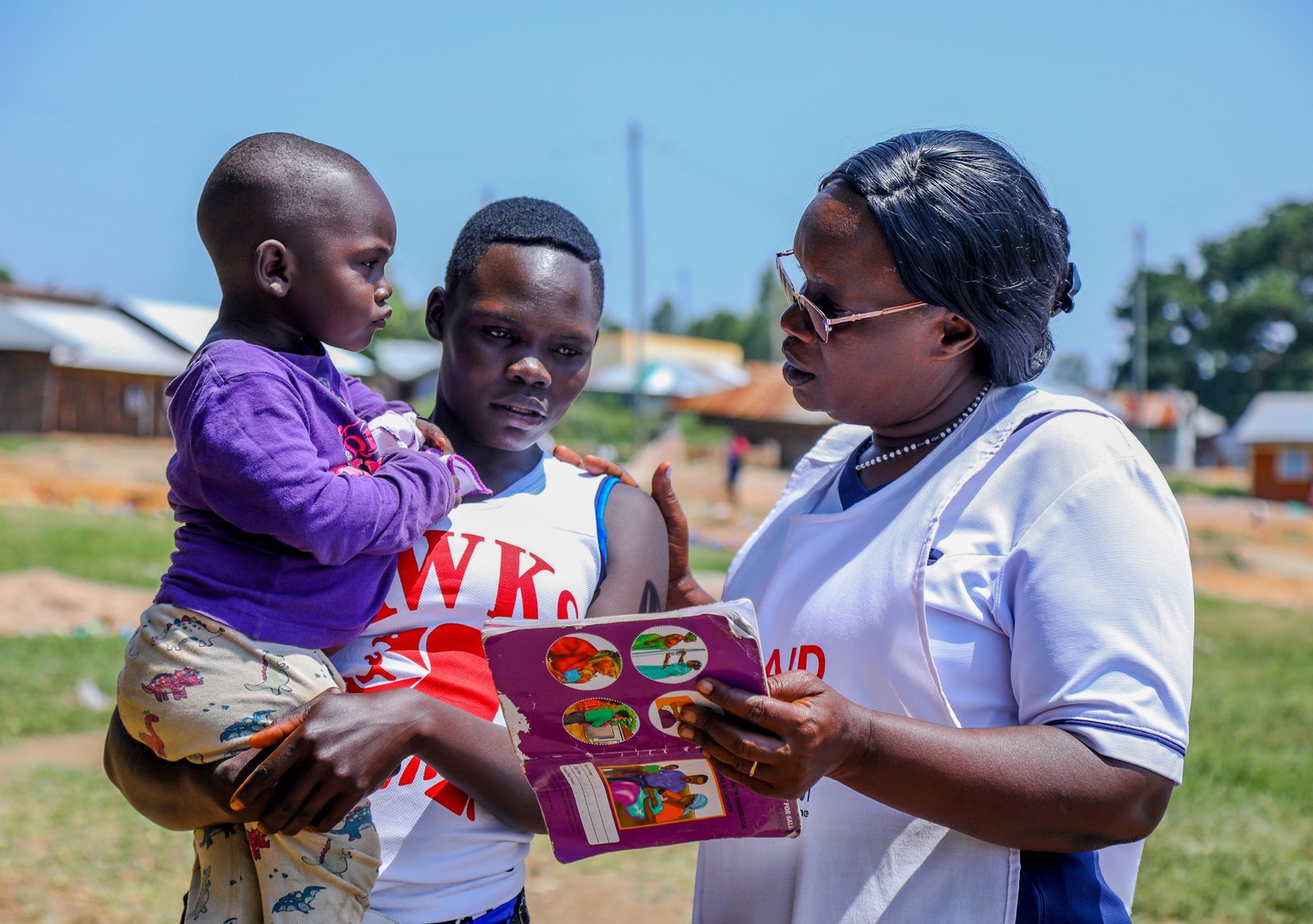 Kendu Bay Sub-County Hospital Vaccines and Immunization Coordinator, Victorine Wasonga (right), speaks with Jane Awuor and her 2-year-old child, Shirley Marion, about the importance of timely childhood vaccination against life-threatening diseases.
