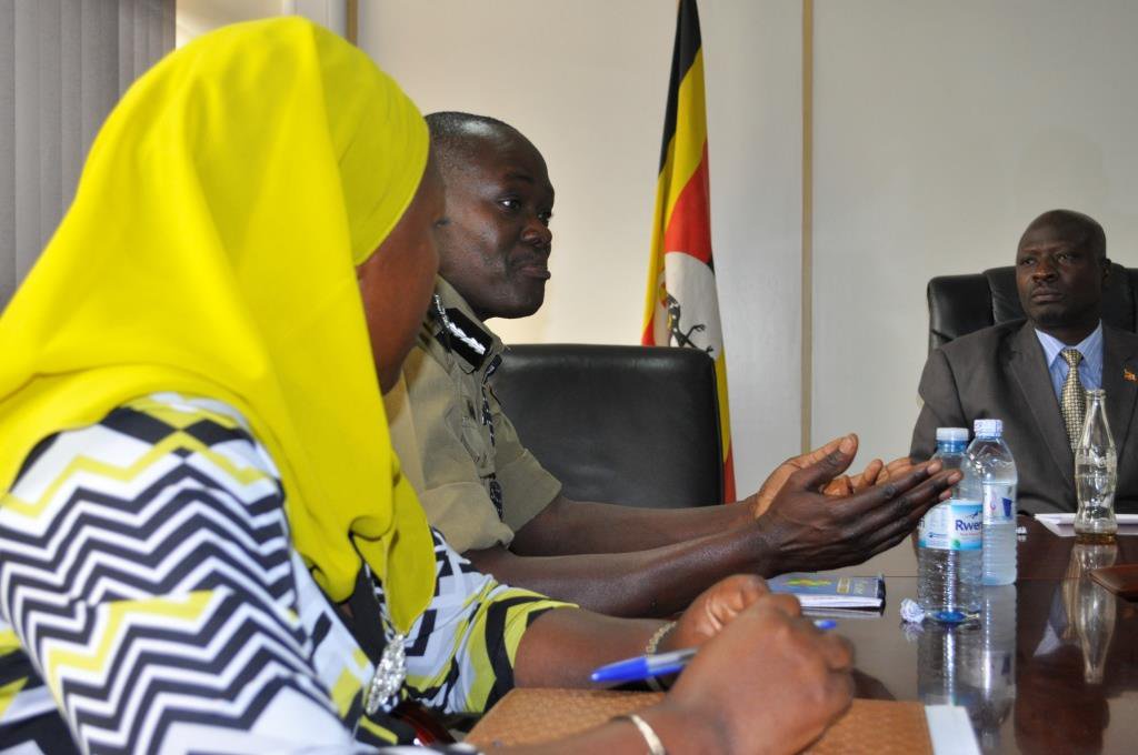 A man speaks while two people look on.