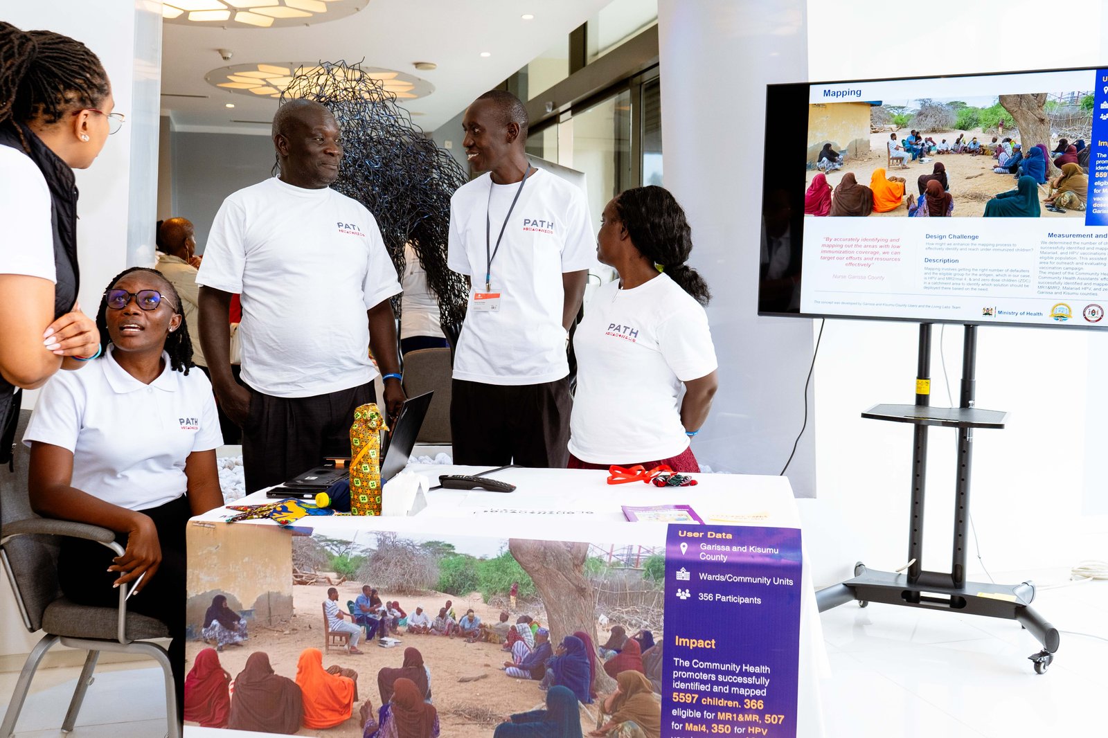 Photo: PATH. Living Labs team members Maryann and Mouline discuss Mapping with users Shadrack, a Community Health Advocate from Kisumu County, and Linda, a Healthcare Worker from Kakamega County.