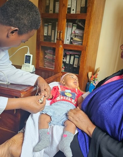 Joyce Nuhu, a clinical officer from Nguvumali Health Center in Tanga, attending to a sick baby using a handheld pulse oximeter. Photo: PATH/Olgah Odek