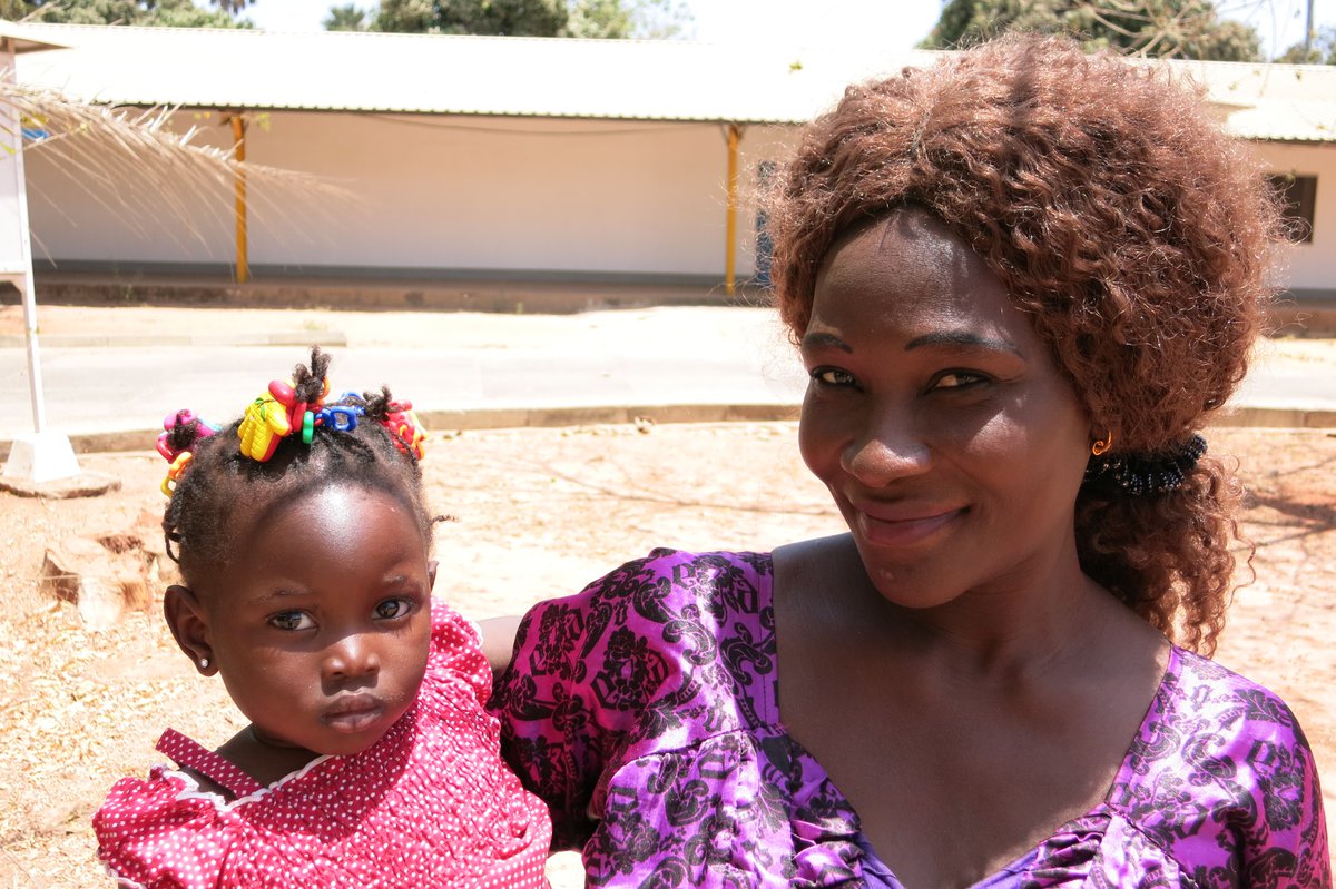 Binta Jammeh holding her toddler daughter Sohna.