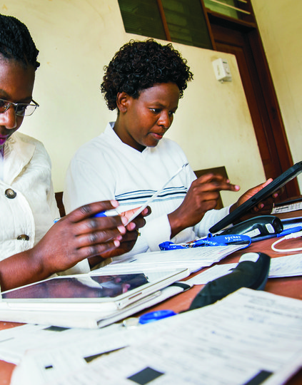 RG451934-edit-2000px.jpg Tanzania healthcare workers working on mobile digital devices. Photo: PATH (BID/digital health via Hallie)