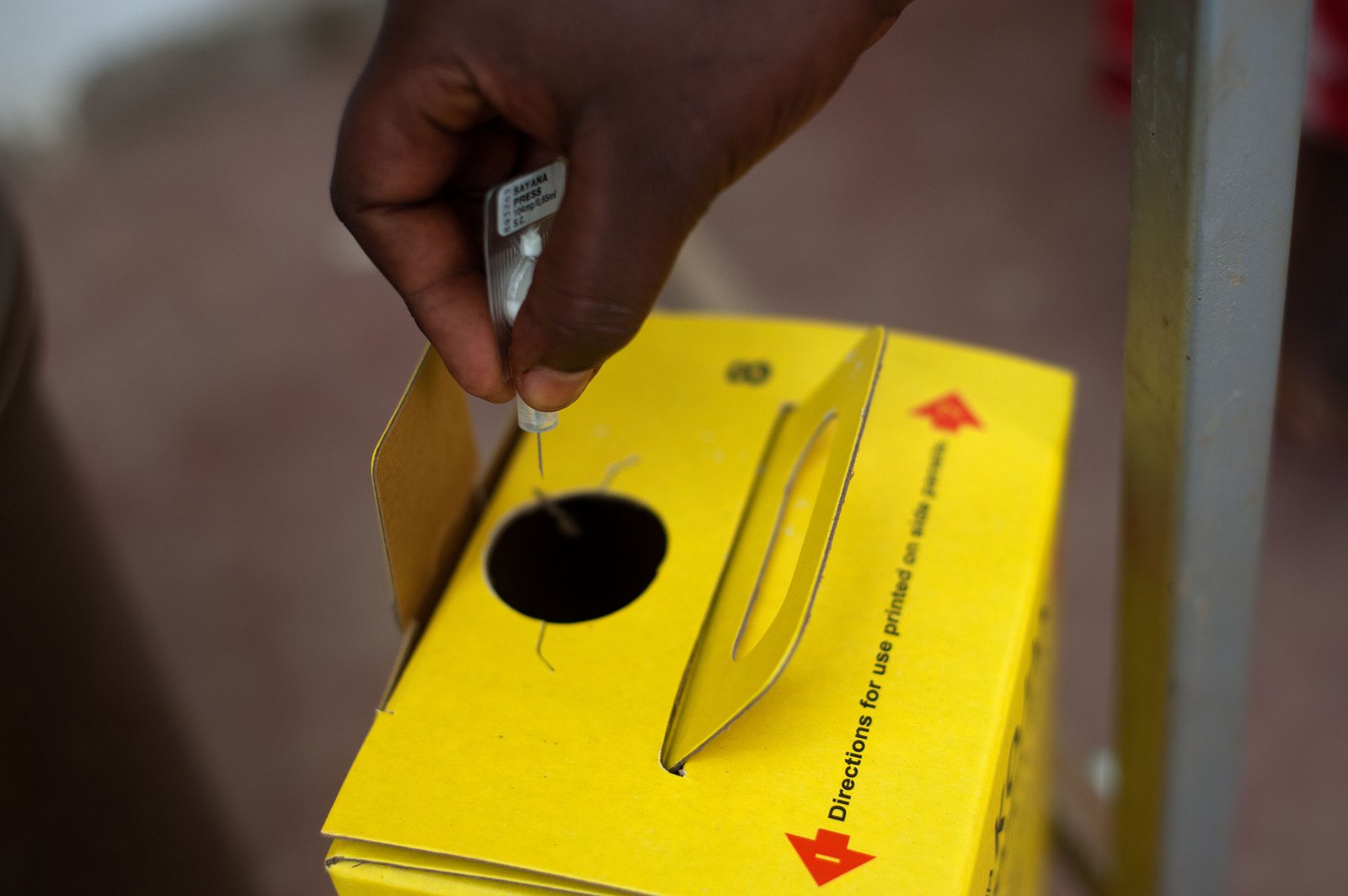 A health worker throws away a used injectable.