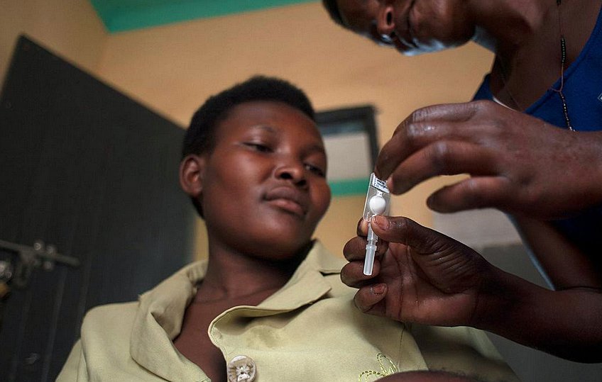 Woman looks on as Sayana Press shot is prepared.