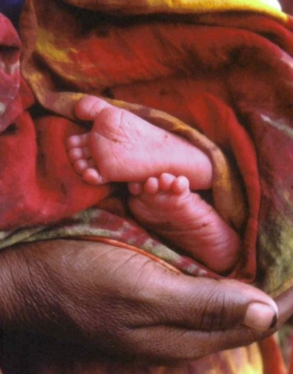 A caregiver cradles a young infant.  Photo: PATH.