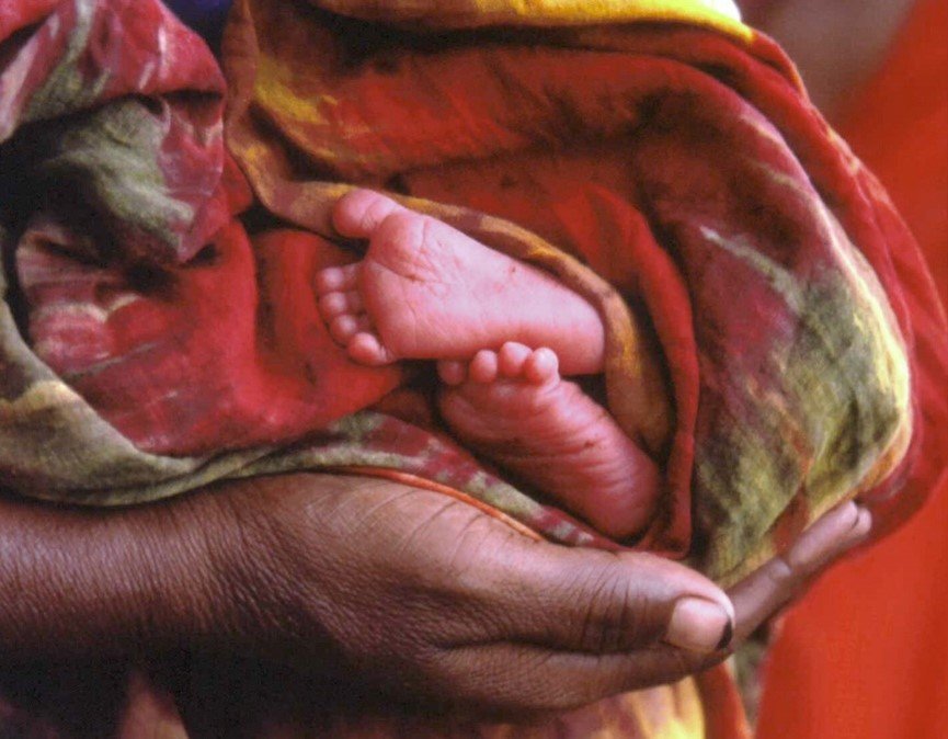 A caregiver cradles a young infant.  Photo: PATH.