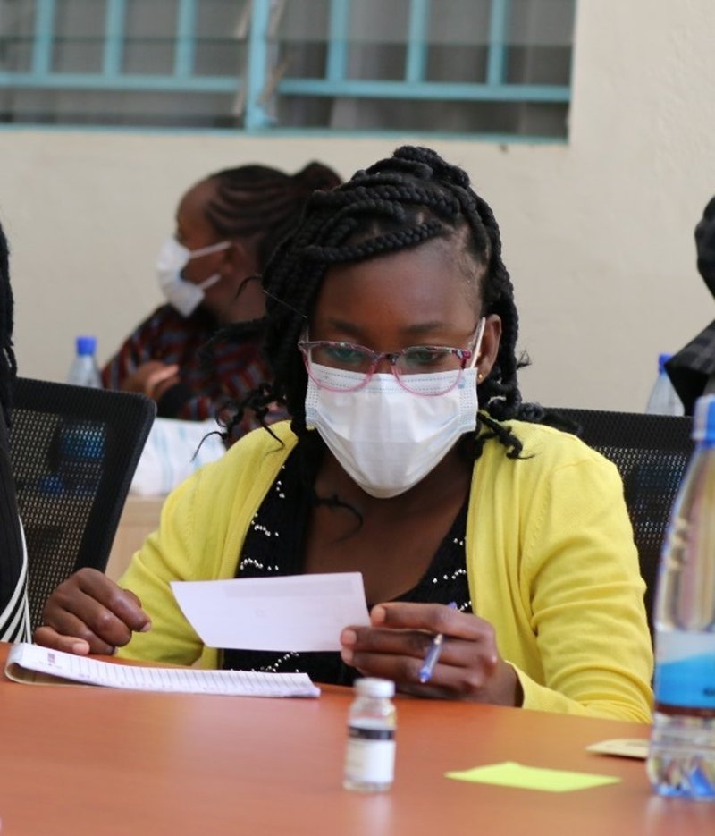 Nancy Otieno, a health care worker at the Kakamega Provisional General Hospital, analyzes a paper prototype of a COVID-19 vaccine vial label at a workshop in Kakamega County, Kenya.