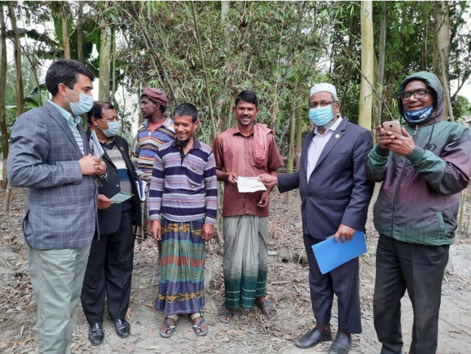 The Assistant EPI Director poses with a family receiving COVID-19 vaccines as part of the Kurigram campaign in December 2021. Photo: Bangladesh EPI/Dr. Borhan Siddiqui.